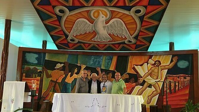 El padre Ángel y acompañantes, junto al mural de Mino Cerezo