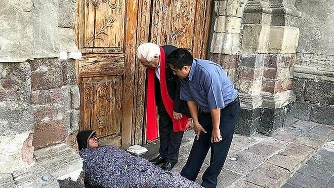 El padre Ángel y el padre Benito saludan a una persona sintecho