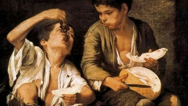 Dos niños comiendo melón y uvas