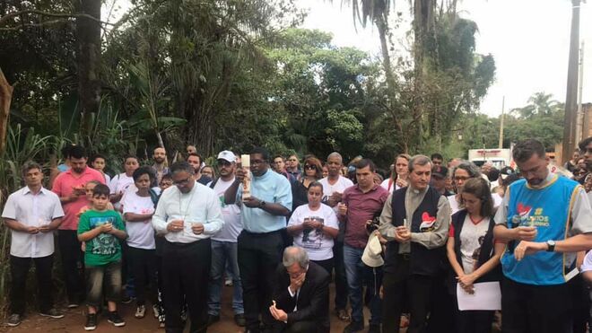 Monseñor Duffé, de rodillas en el centro, reza en el lugar de la tragedia de Brumadinho
