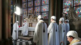 El arzobispo parisino Michel Aupetit, segundo de izquierda a derecha, preside la primera misa en una capilla de la catedral de Notre Dame, dos meses después de el devastador incendio