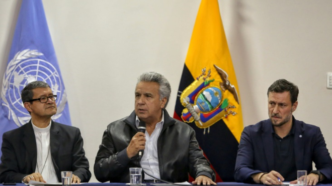 El presidente ecuatoriano Lenín Moreno (C), flanqueado por el arzobispo Luis Gerardo Cabrera Herrera (I) y el representante de ONU Arnaud Perald