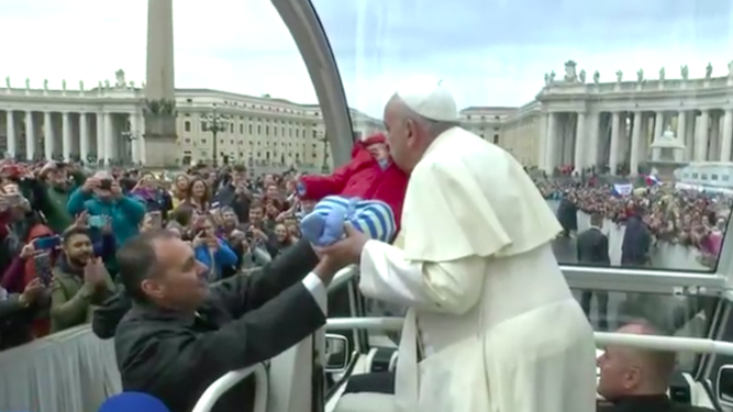 Francisco besa a un niño en la plaza de San Pedro
