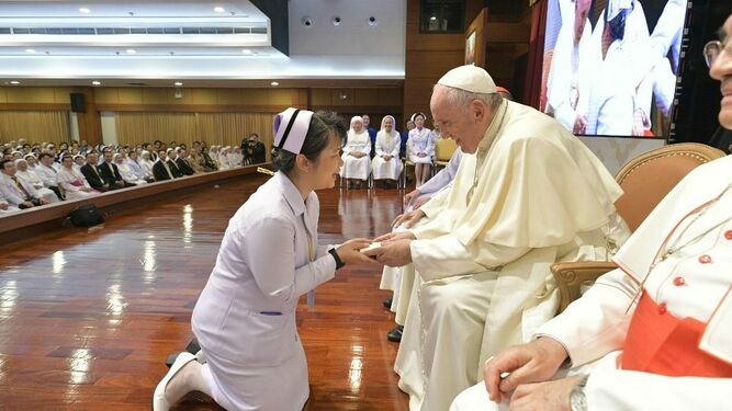 Una enfermera se arrodilla ante el Papa