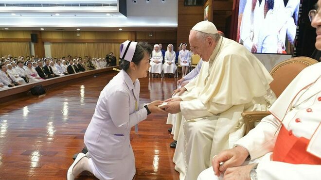 Una enfermera se arrodilla ante el Papa