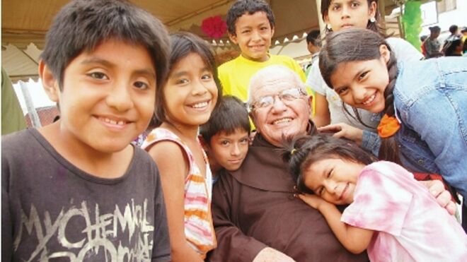 El padre Alfredo, rodeado de niños, para quienes fue un regalo