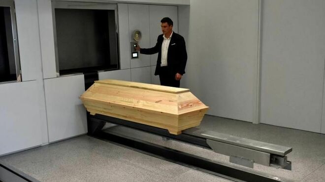 Un operario prepara un ataúd poco antes de entrar en la incineradora del primer crematorio inaugurado en Atenas (Grecia)
