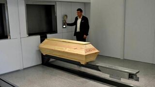 Un operario prepara un ataúd poco antes de entrar en la incineradora del primer crematorio inaugurado en Atenas (Grecia)