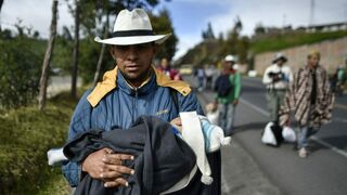 Un migrante venezolano con su hijo en camino hacia Perú