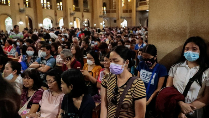 Fieles con mascarilla ante la epidemia