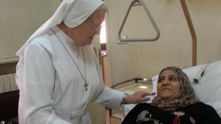 Una religiosa cuida de una víctima del conflicto en Siria