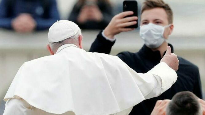 El Papa saluda a un fiel que le graba con una mascarilla puesta