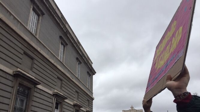 Un joven alza un cartel feminista, en medio de la multitud de la "revuelta" de mujeres
