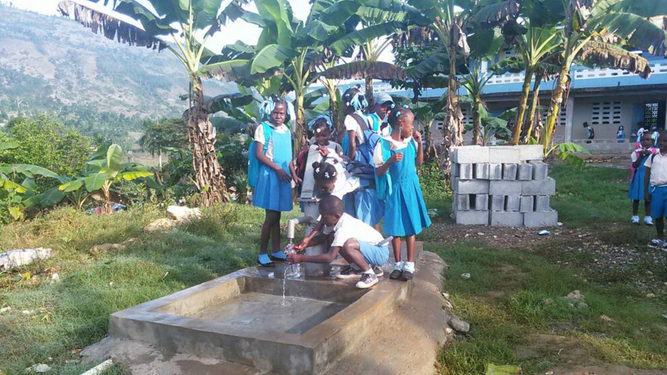 Estudiantes en una fuente de agua potable en una escuela católica de Jérémie