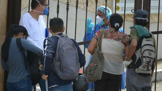 Familiares con mascarillas hacen consultas para poder despedir a sus seres queridos en un cementerio de Guayaquil (Ecuador)