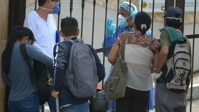 Familiares con mascarillas hacen consultas para poder despedir a sus seres queridos en un cementerio de Guayaquil (Ecuador)
