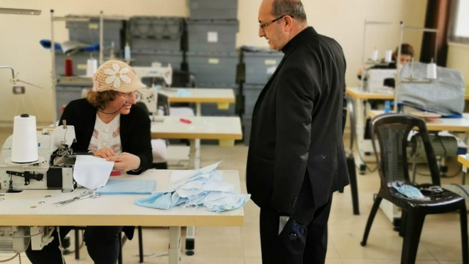 El padre Carlos supervisa el taller donde están confeccionando las mascarillas