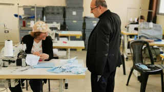 El padre Carlos supervisa el taller donde están confeccionando las mascarillas