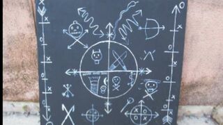 Signos del acto satánico dibujados en una lápida.