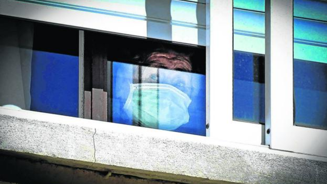 Anciana en la ventana de una residencia