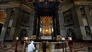Un operario pulveriza la zona del baldaquino  de Bernini