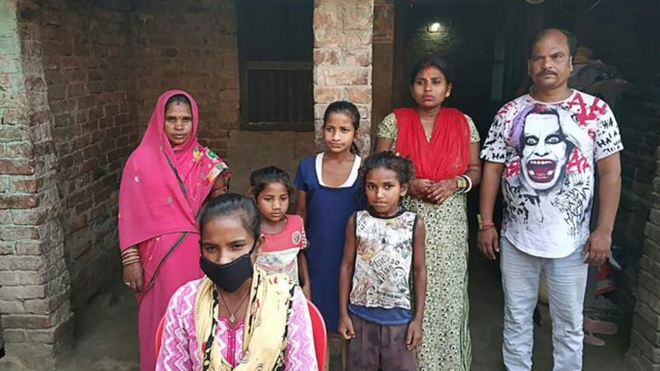 La joven Jyoti (con mascarilla) con su familia detrás