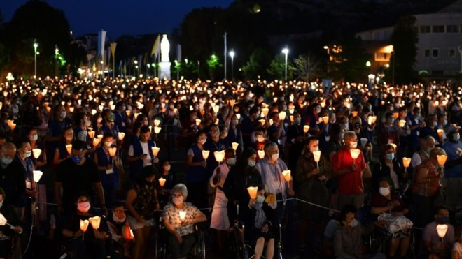 Velas y mascarillas en el santuario de Lourdes, Francia