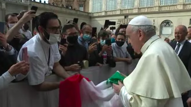 Francisco ora junto a una bandera del Líbano