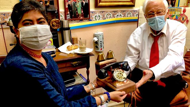Ana María Brea con el padre Ángel sosteniendo uno de los teléfonos