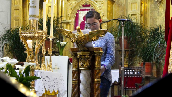 Una joven leyendo en el altar