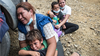 Una migrante llora junto a su hijo tras la carga de la policía