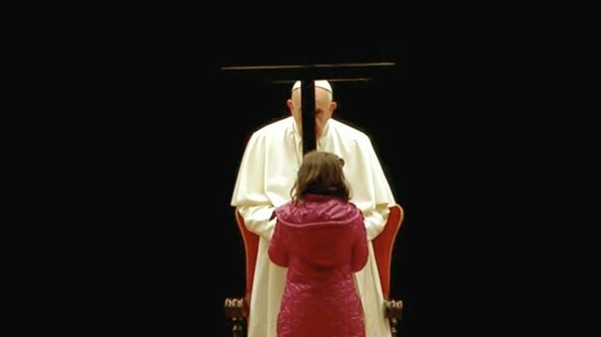 Una niña entrega la cruz al papa