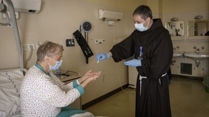 Sacerdote italiano visita a una mujer hospitalizada.