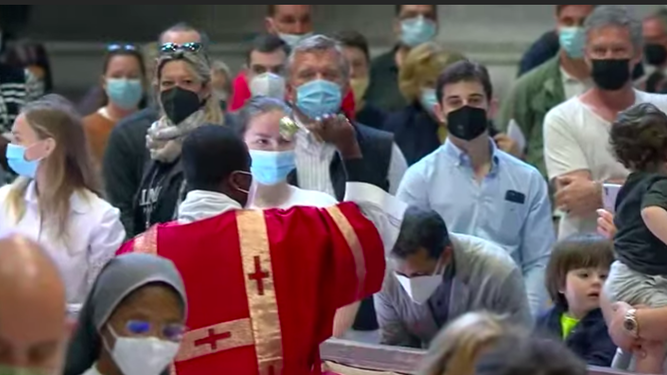 Un sacerdote bendice con el agua a los fieles