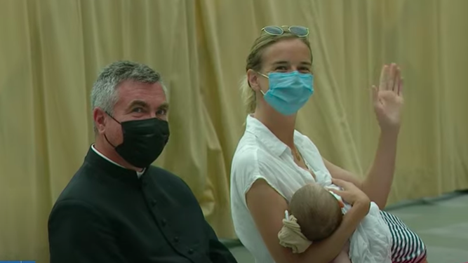 Un sacerdote, una madre y su hijo saludan al Papa