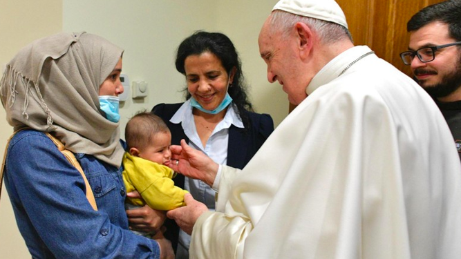 Francisco abraza a un niño y su madre