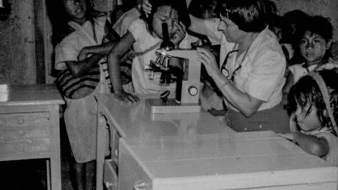Sofía Toro le enseña a un grupo de niños cómo usar el microscopio