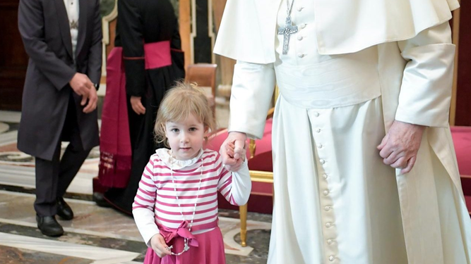 El Papa de la mano con una niña