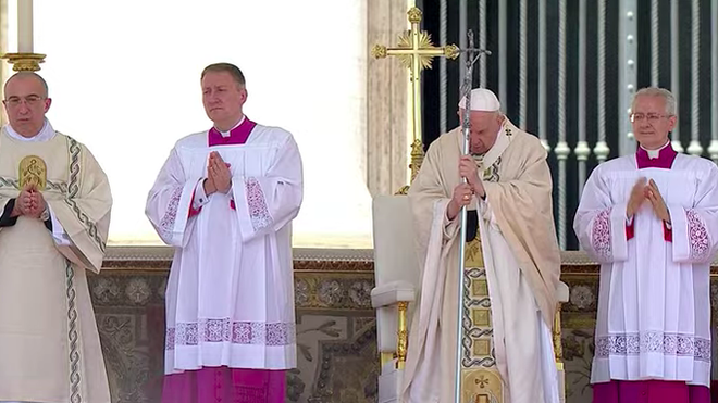Francisco, en pie, escucha el Evangelio