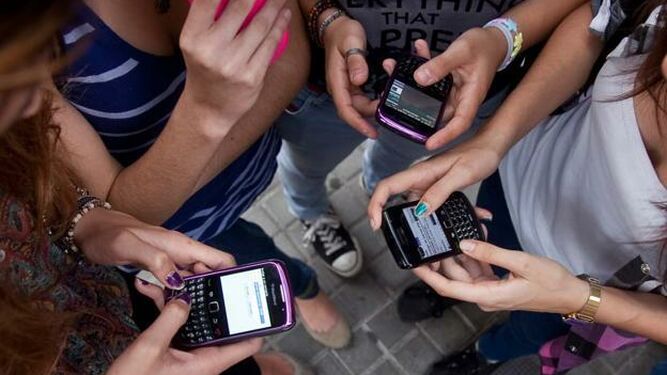 Jóvenes con su móviles usando redes sociales