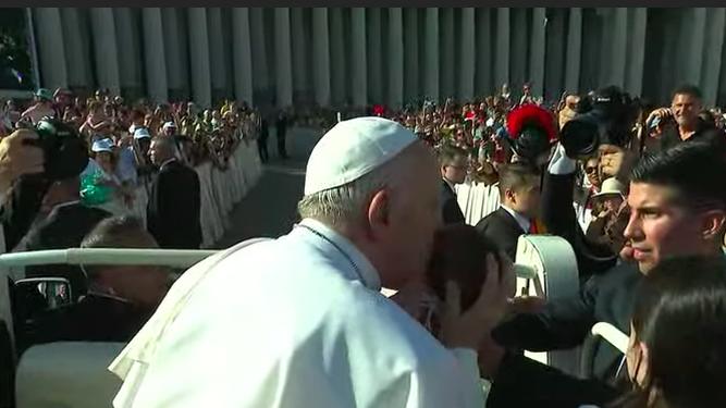 El Papa besa a un niño en la plaza de San Pedro