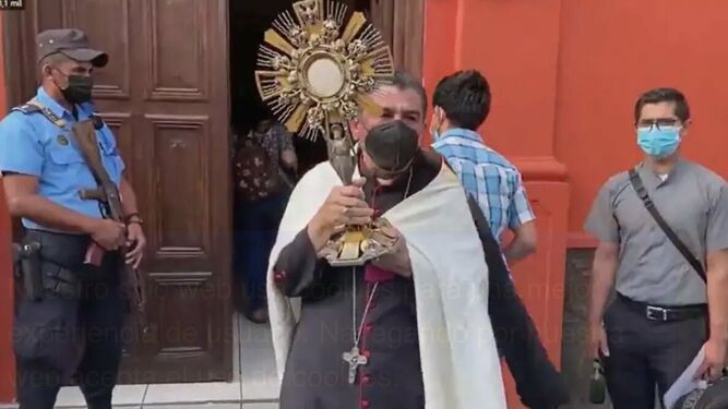 Rolando Álvarez, portando el Sagrado ante la mirada de la Policía