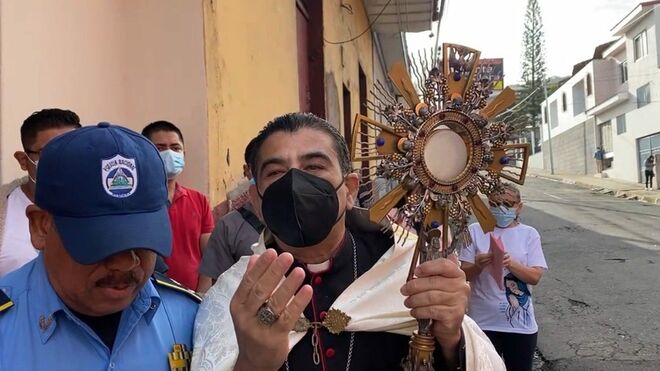 Rolando Álvarez, portando el Sagrado ante la mirada de la Policía
