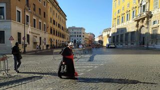 El cardenal Burke, con gorro de paja, entrando en el Vaticano