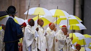 Omella, junto a otros cardenales, se protege de la lluvia durante la beatificación