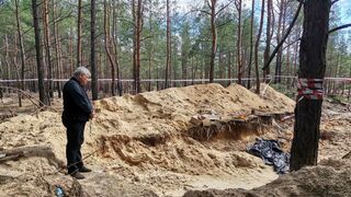 El cardenal Krajewski reza ante una fosa común en Ucrania