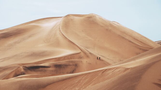 Dos personas caminan por el desierto