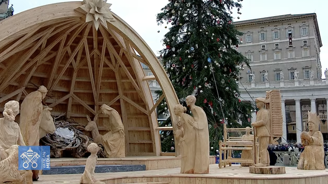 El belén instalado en la plaza, al fondo, el Papa en el balcón
