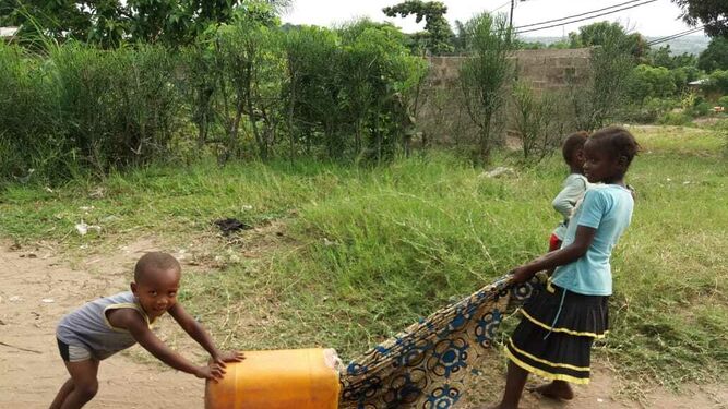 Niños acarreando un bidón de agua en la comunidad del P. Riaño