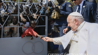 La foto del viaje a Sudán: una niña dando limosna al Papa Francisco